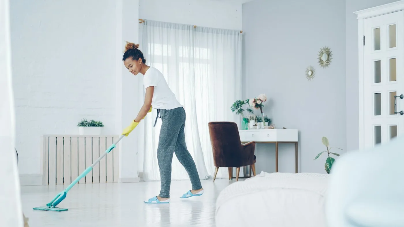Cleaner mopping a bright living room